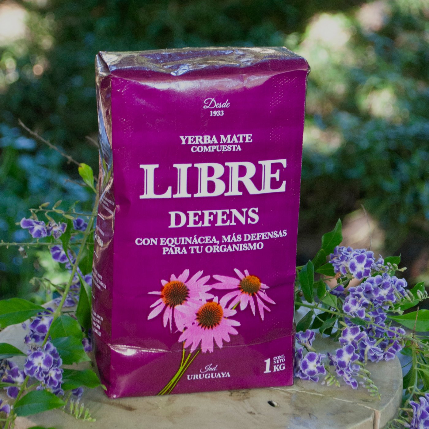 yerba LIBRE Defens 1 kg sobre madera con flores